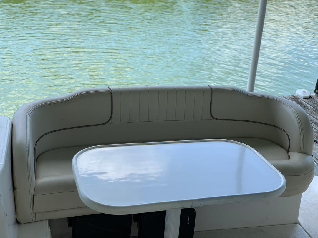 Seat and table setup inside the white mini yacht cruiser boat rental at Lake Lewisville